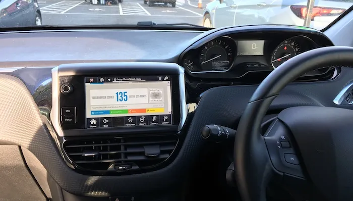 Dashboard of a car showing a web browser with HTML5test loaded